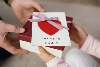 Little girl giving her father gift box father s day