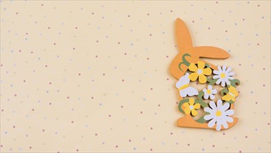 Wooden rabbit with flowers beige table