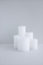 Close up white candles against grey background