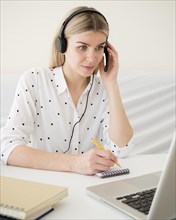 Online classes with student holding her headphones