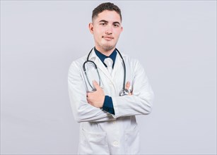 Portrait of handsome doctor with arms crossed isolated. Latin doctor with crossed arms on white background