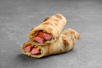 Thin sausage rolled and baked in dough with cabbage