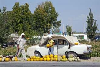 Improvised fruit stand selling melons along road in Uzbekistan