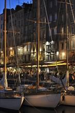 Sailing boats and tourists at pavement cafes