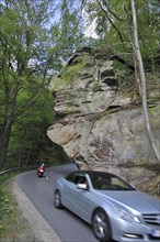 Car driving under the sandstone rock formation Predigtstuhl in Berdorf