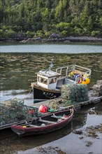 Moored small fishing boat and lobster pots