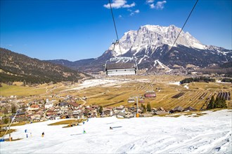 Plattensteig ski slope in the Grubigstein ski area with a view of the Zugspitze and the valley town of Lermoos