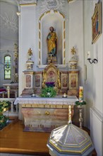 Side altar with holy figure and baptismal font