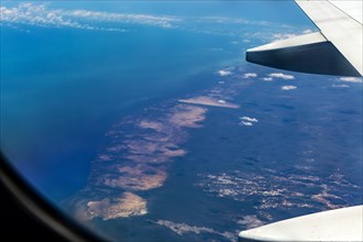 Oblique angle aerial view through plane window over Gulf of Mexico coast