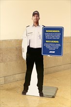 Cardboard security guard reminder about liguid gels at security check inside Cancun airport
