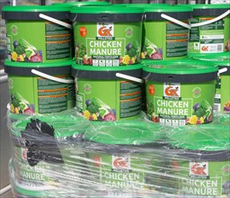 Plastic tubs of Vitax pelleted chicken manure natural fertiliser at plant nursery