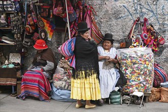 Old women with traditional hats at market stall with souvenirs on display at the witch's market in La Paz