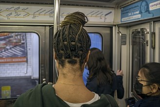 Woman with braided pigtails in the metro