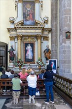 People praying at altar inside cathedral church