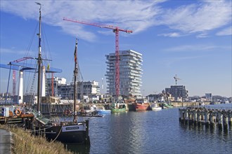 Two-master sailing vessel Nele and new flats being build for real estate project Oosteroever in the Ostend harbour along the Belgian North Sea coast