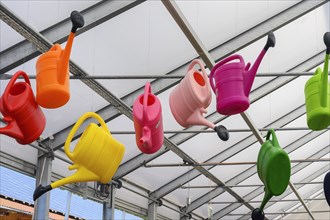 Colourful watering cans in a garden centre