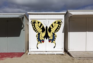 White beach hut painted with butterfly