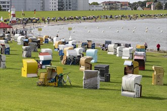 Beach chairs on a green meadow with dyke on the beach of Cuxhaven