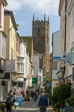 Shops in historic buildings along alleyway with tower of church of St Saviour