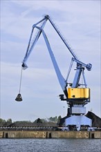 Dock crane and coal heap along the Ghent-Terneuzen Canal at Ghent seaport