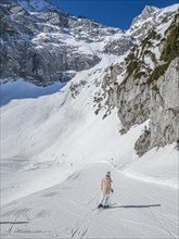 Skier on the Osterfelder downhill run between high mountain flanks