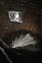 Narrow stone spiral staircase with loophole in the medieval Beersel Castle