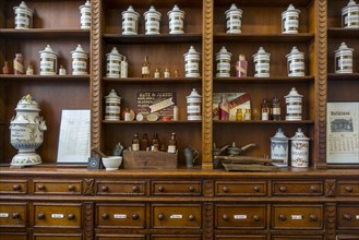 Antique pharmacy cabinet with vintage porcelain jars in the Hopital Notre-Dame a la Rose