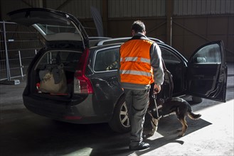Car being searched for explosives and drugs by handler with explosive-detection dog of the Securitas K9 Explosive Detection Team