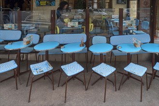 Turquoise bistro tables and chairs in front of a bistro