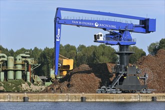 Dock crane and scrap heap along the Ghent-Terneuzen Canal at Ghent seaport