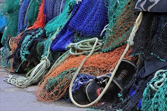 Colourful trawler fishing nets on the quay in Lyme Regis harbour along the Jurassic Coast