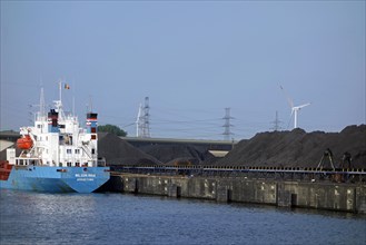 Bulk carrier docked in front of heaps of coal at SEA-invest