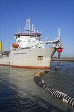 Trailing suction hopper dredger Alexander von Humboldt in port of Ostend discharging sand via long hoses