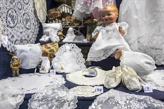 White Belgian bobbin lace for sale as tourist souvenirs in shop window of gift shop