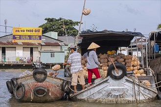 Vietnamese farmers selling pumpkins from traditional wooden boat at the floating market of the city Can Tho in the Mekong Delta