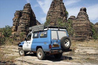 Four-wheel drive vehicle and the sandstone rock formations called Domes de Fabedougou near Banfora
