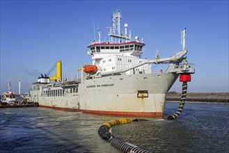 Trailing suction hopper dredger Alexander von Humboldt in port of Ostend discharging sand via long hoses