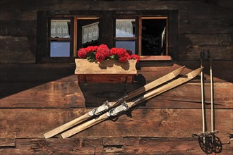 Housefront of traditional wooden house decorated with old skis in the Alpine village Grimentz