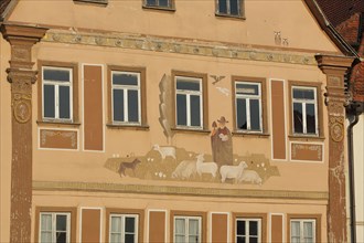 Mural with shepherd and flock of sheep on historical building with pilaster
