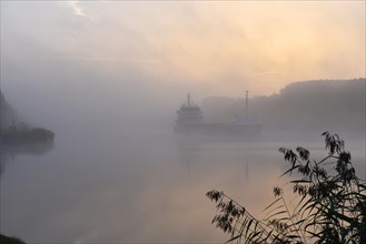 Cargo ship sailing in fog in Kiel Canal