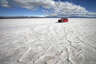 Red tourist car on the Salar Grande in the Jujuy province of Argentina