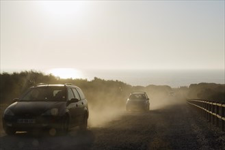 Cars driving on dusty track