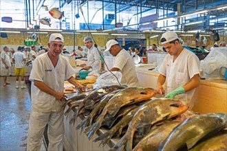 Fishmongers cleaning fishes at the covered fish market in the capital city Manaus
