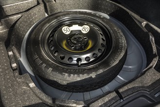 Space-saver spare wheel in trunk of car with limited speed limit of maximum 50 mph 80 km h