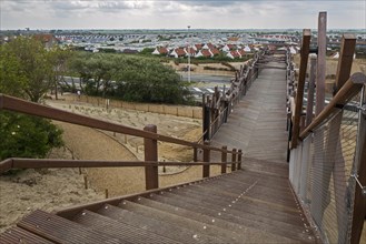 The wooden footbridge Het Wrakhout and holiday resort along the North Sea coast at Westende