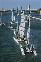 School children on catamarans leaving the Cherbourg port during sailing class in Normandy