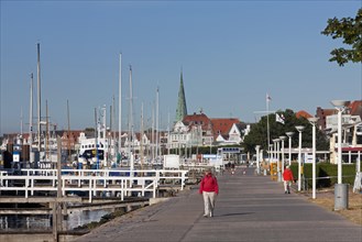 Tourists walking on the Promenade Vorderreihe along the river Trave at Travemuende