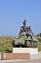 Teenagers on Second World War Sherman tank as monument near Utah Beach