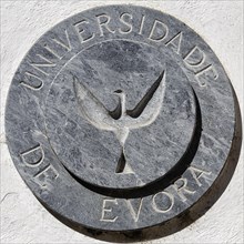 Coat of arms of the University of Evora on a house wall