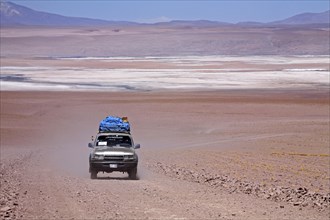 Four-wheel drive vehicle driving on dirt-track on the Altiplano in Bolivia